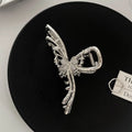 Silver metal hair claw barrette showing one of 45 designs, such as a bow or rose, on a white background.