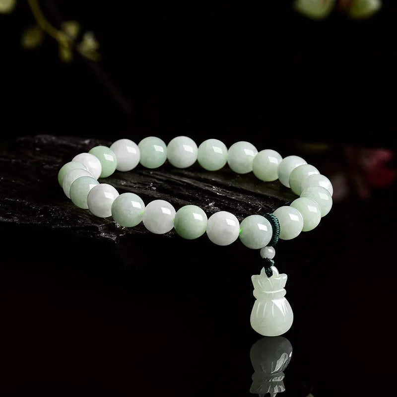 Close-up of an 8mm floral carved jade bracelet on a wrist.