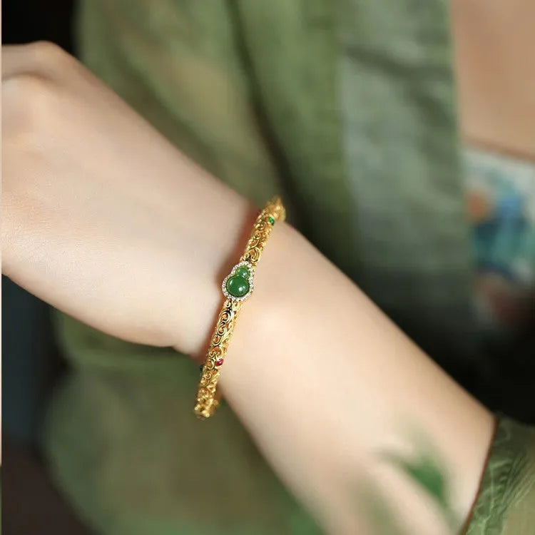 Retro-style open copper bracelet with a detailed gourd charm on a wrist.