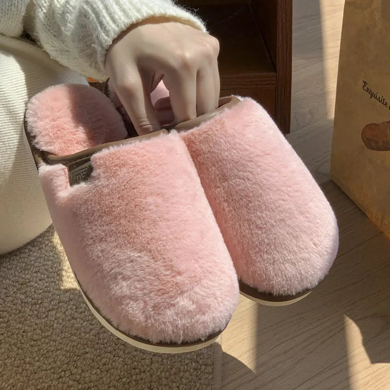 Pair of solid-colour plush house slippers with car stitching detail on the PVC upper.