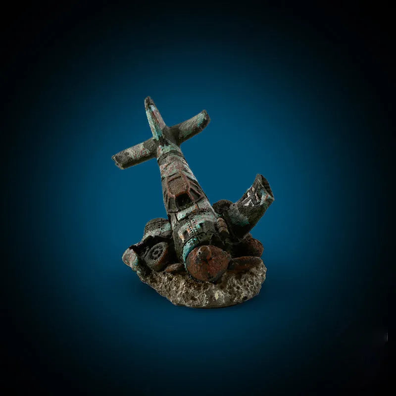 Resin simulated aircraft wreckage aquarium ornament 8cm by 4.5cm by 4.5cm on dark substrate