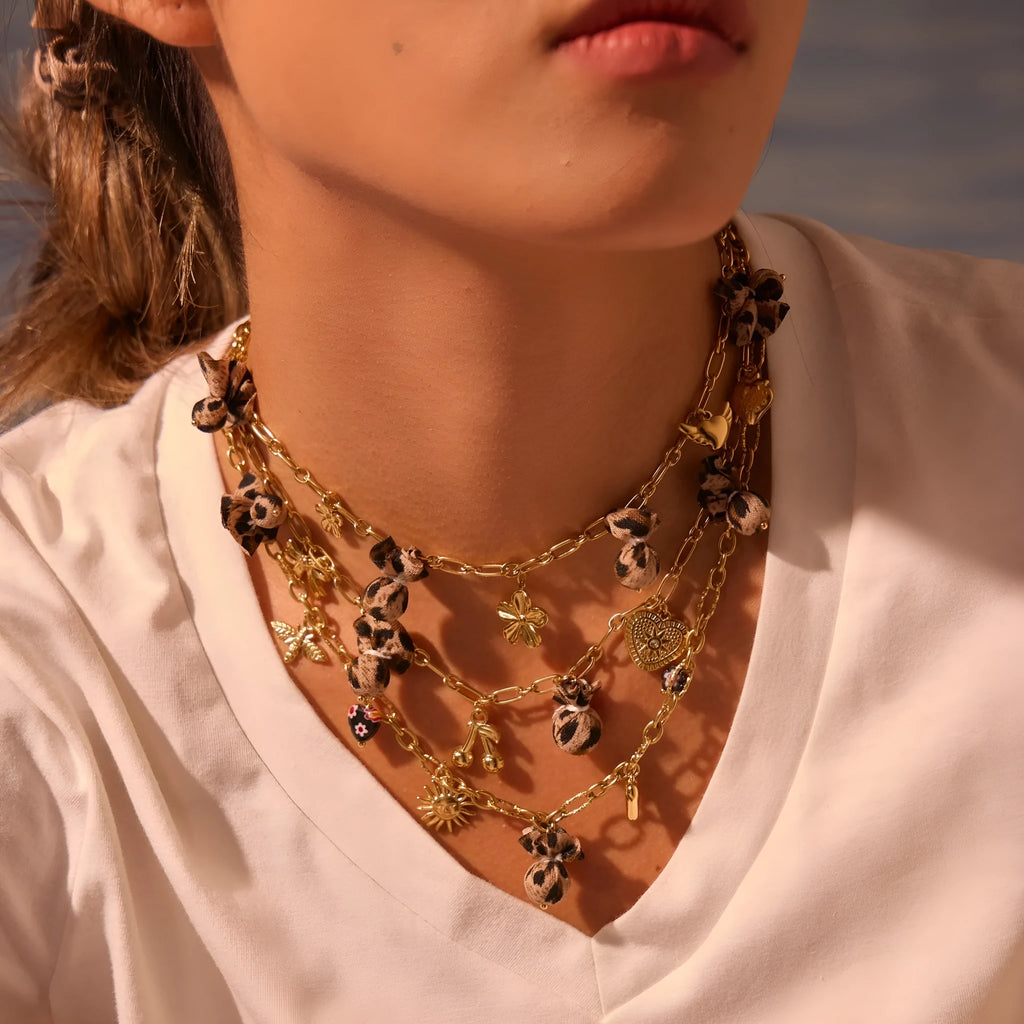 Stainless steel necklace with a geometric leopard pendant and heart and flower accents on an adjustable chain.