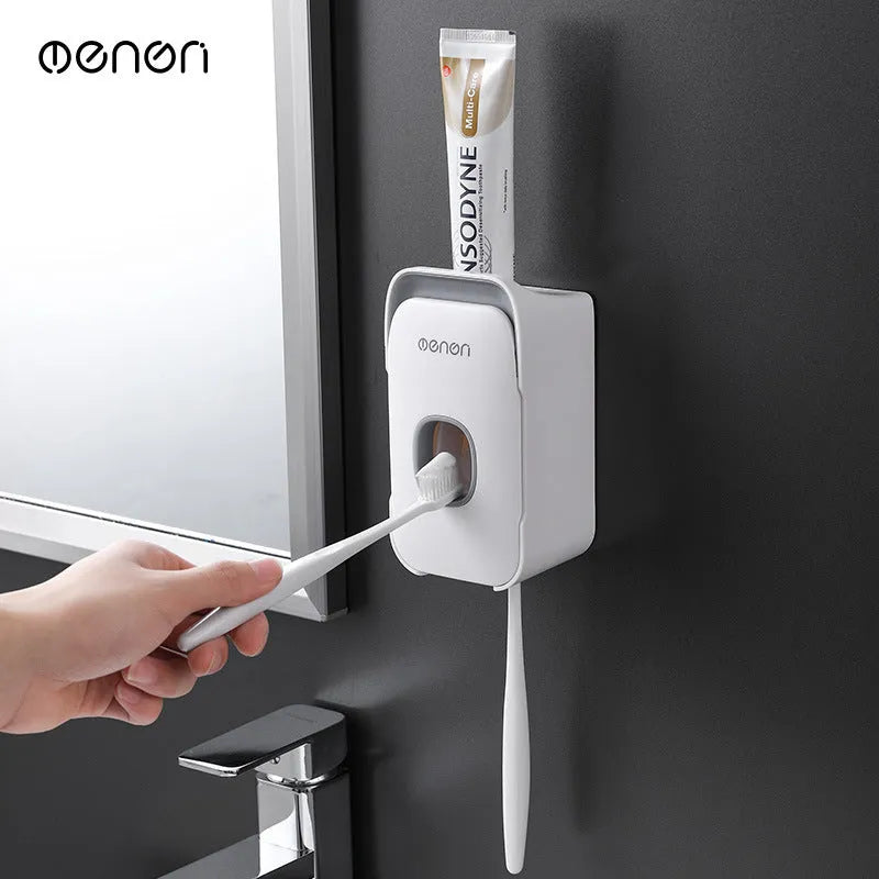 Blue automatic wall-mounted toothpaste dispenser with a sensor for touchless operation on a bathroom wall.