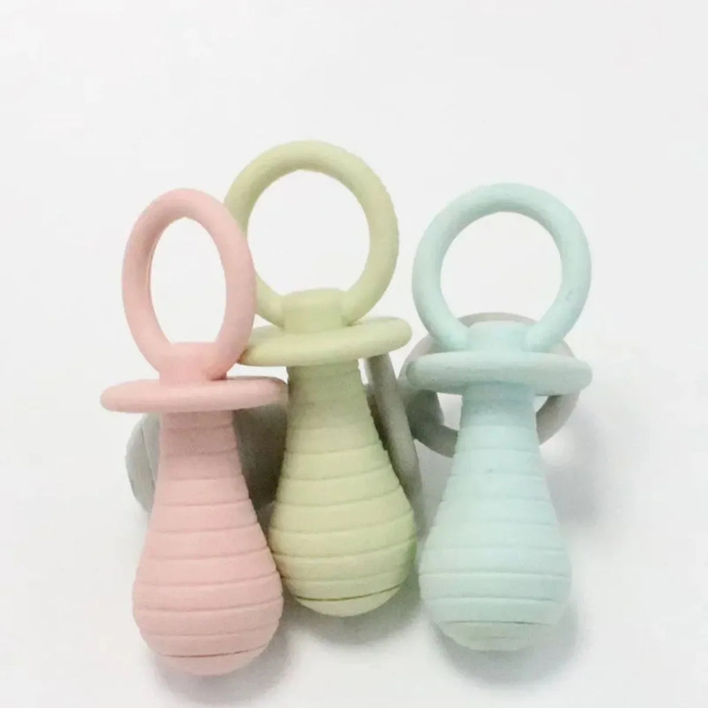 Four TPR rubber pet pacifier chew toys with squeakers in blue, grey, green, and pink colours