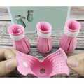 Set of four adjustable cat foot claw covers in light blue, light green, and pink, made from TPE with drainage holes and Velcro straps.