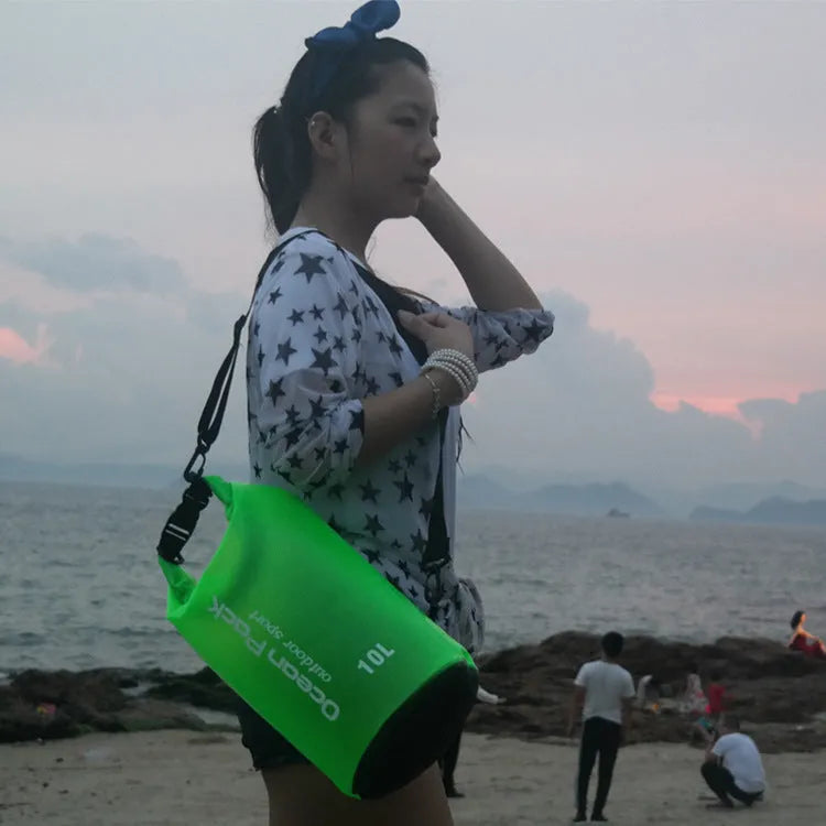 Waterproof PVC bucket bag in blue on beach, 15L size showing drawstring closure and bucket shape