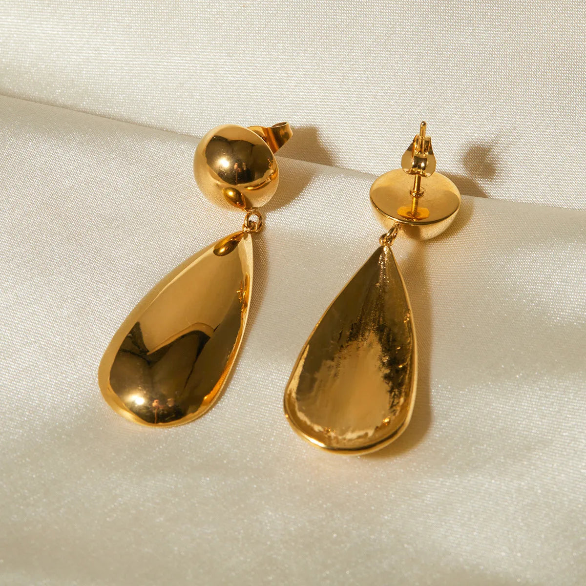 A pair of gold-coloured geometric water drop pendant earrings made from stainless steel.