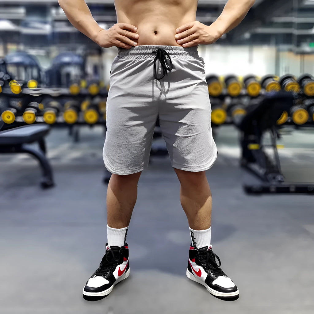 Men's black quick-drying thin running shorts made of nylon and spandex blend on a grey background.
