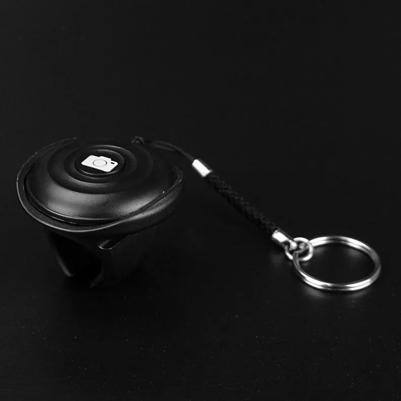 Black plastic Bluetooth remote shutter release for camera and smartphone selfies.
