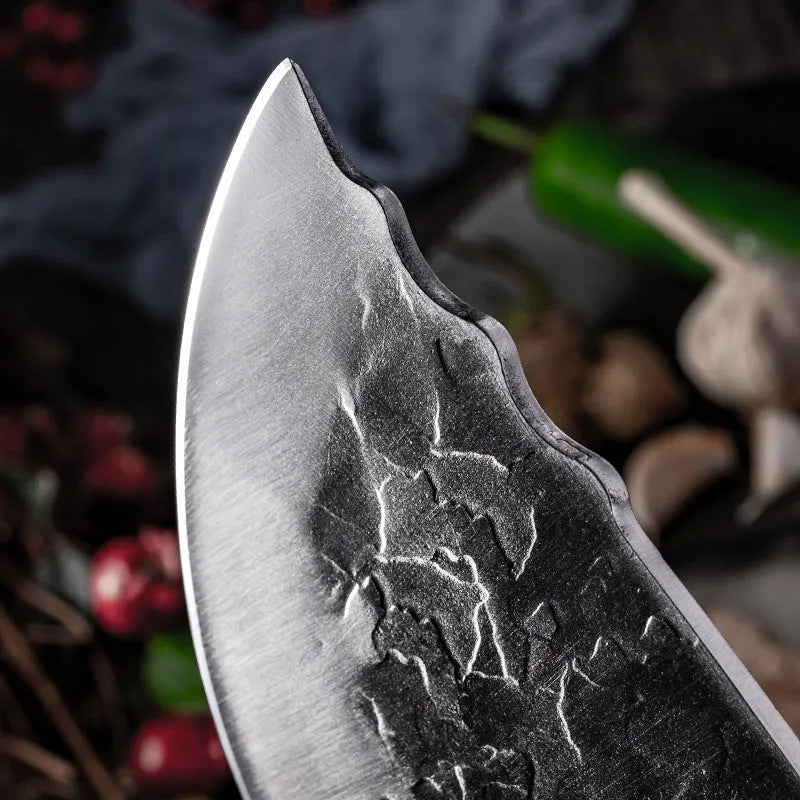 Hand forged stainless steel butcher knife with chicken wing wood handle and copper nails on a cutting board