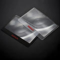 Portable black and white plastic card magnifier for close-up reading.