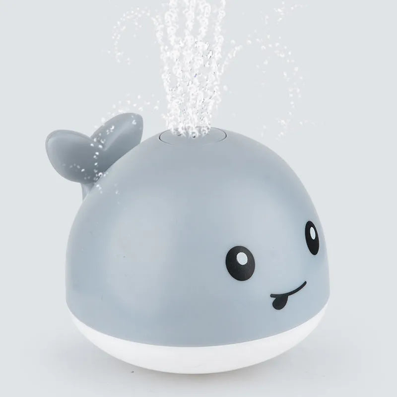 Electric whale-shaped bath spray toy with water-activated automatic spray, LED lights, and floating capability