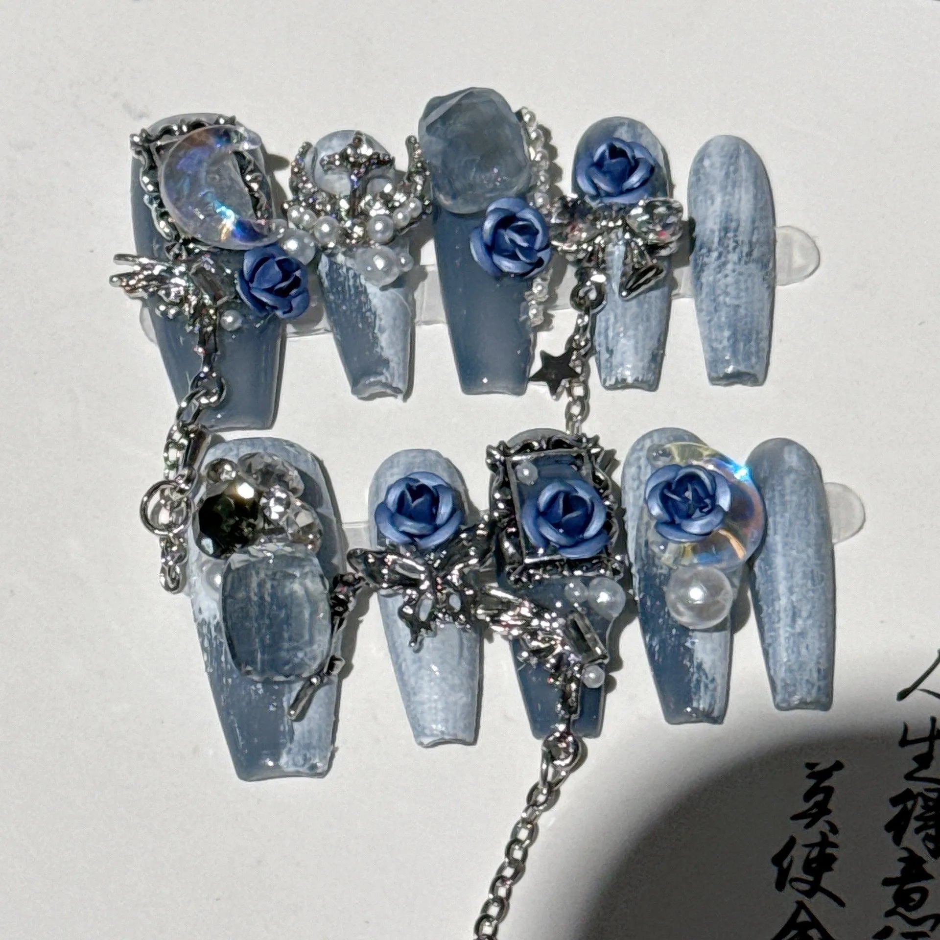 Heavy industry blue night manicure set with rose and tulip floral designs on plastic armour suit.