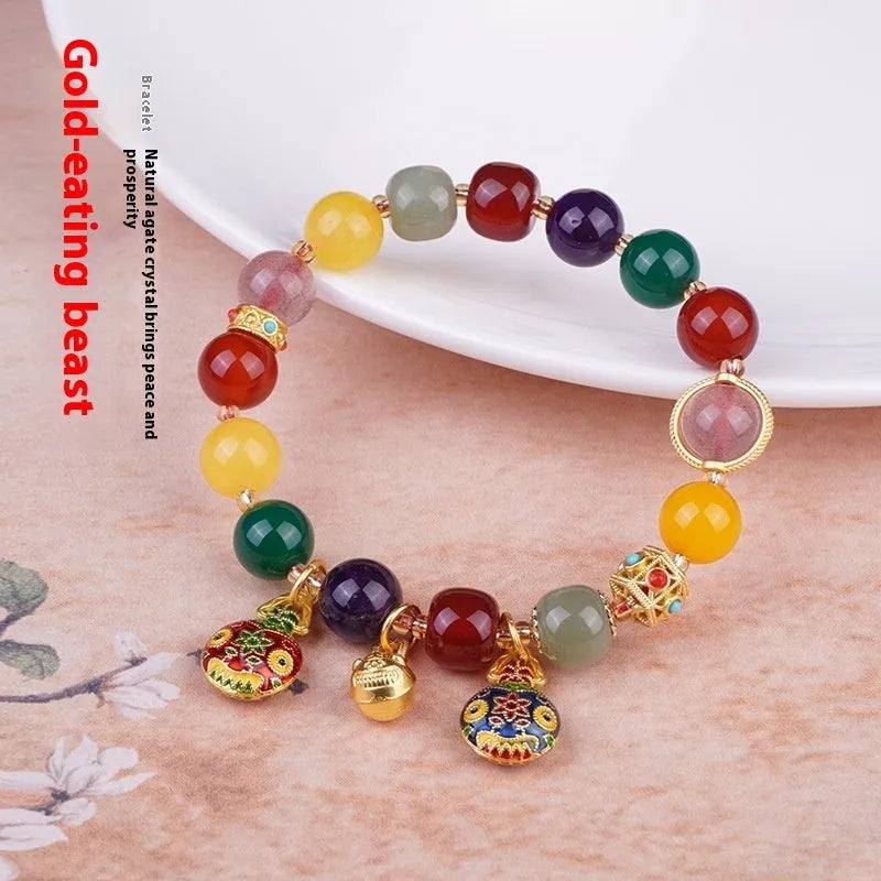 Hand-woven agate bracelet with 10mm swallowing gold beast beads on display
