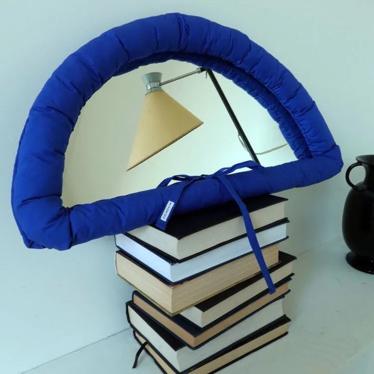 Soft rectangular fabric mirror panel in sapphire blue with a padded texture, shown hanging.