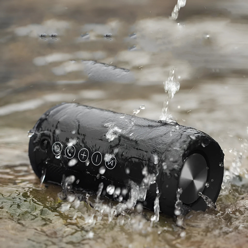 Compact portable outdoor Bluetooth speaker in black, showing control buttons and a speaker grille.
