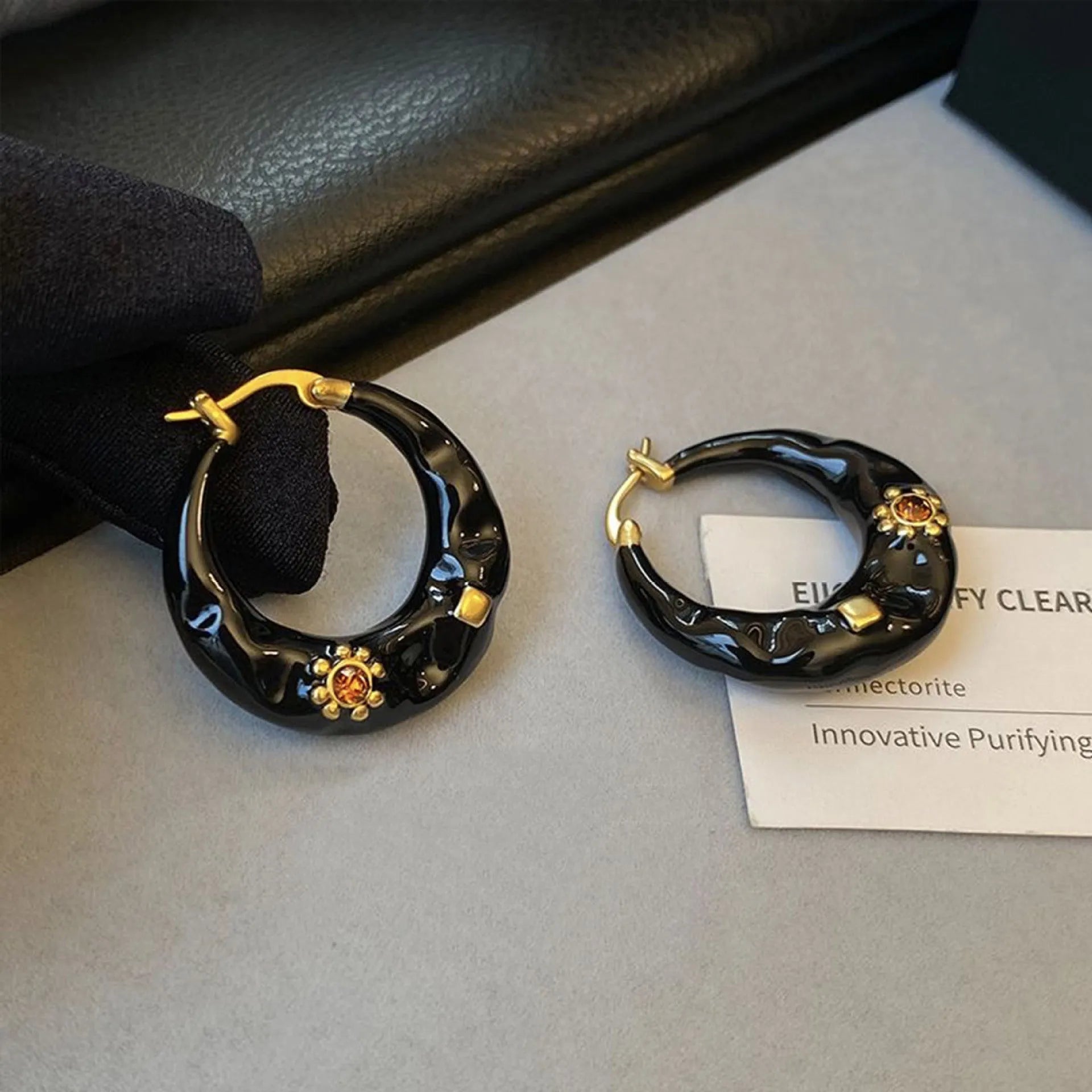A pair of retro-style alloy ear studs with inlaid rhinestones, shown in black and red colour options.