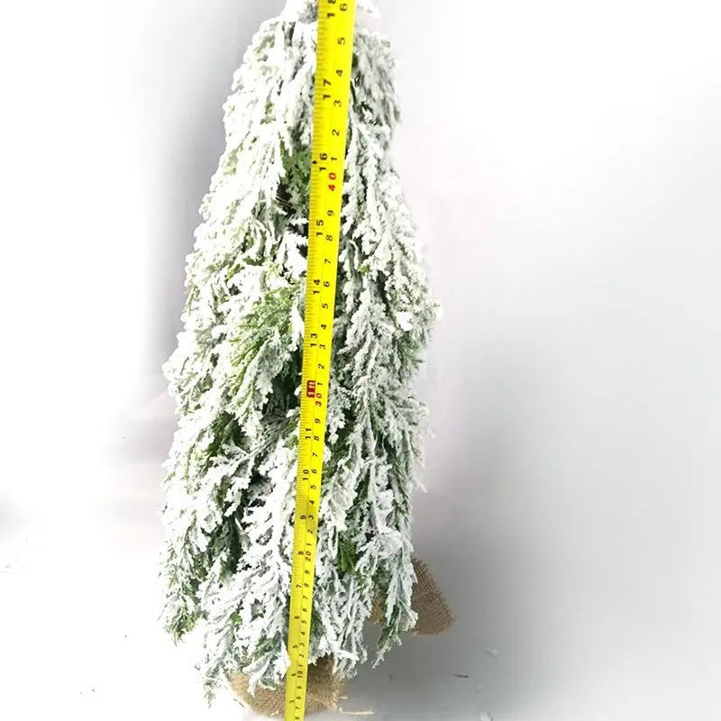 Small 24-inch white artificial Christmas tree with lights and snow spray on a desktop
