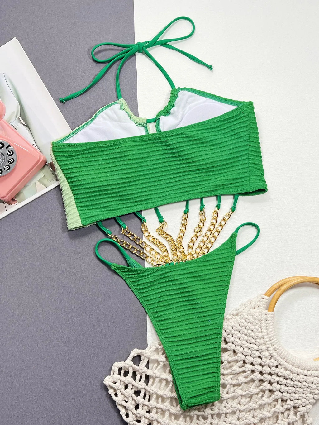 Solid green women's one-piece swimsuit on a hanger, showing hollow design.
