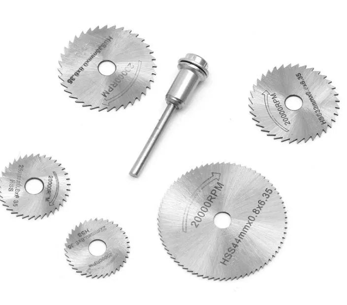 Six or seven high-speed steel circular saw blades and a mandrel on a grey background.