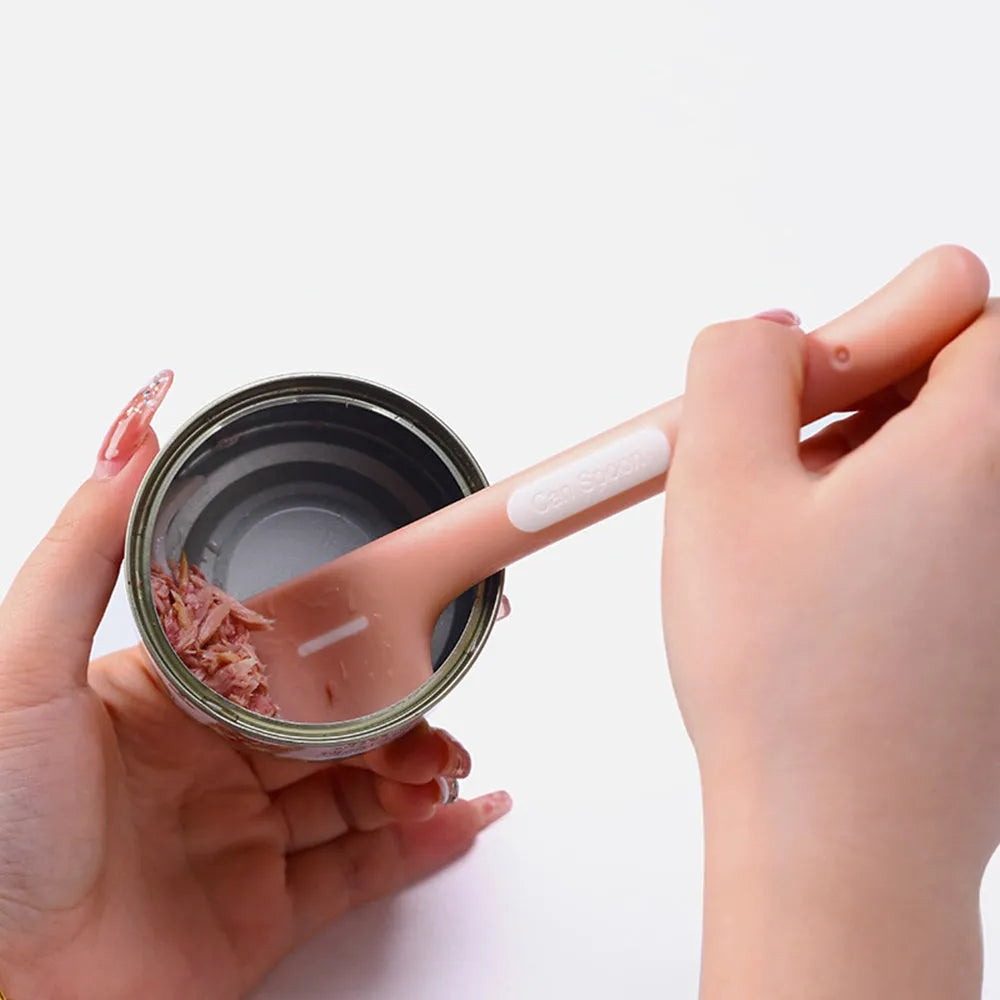 Green long-handled pet food spoon with angled head for scooping canned cat or dog food.
