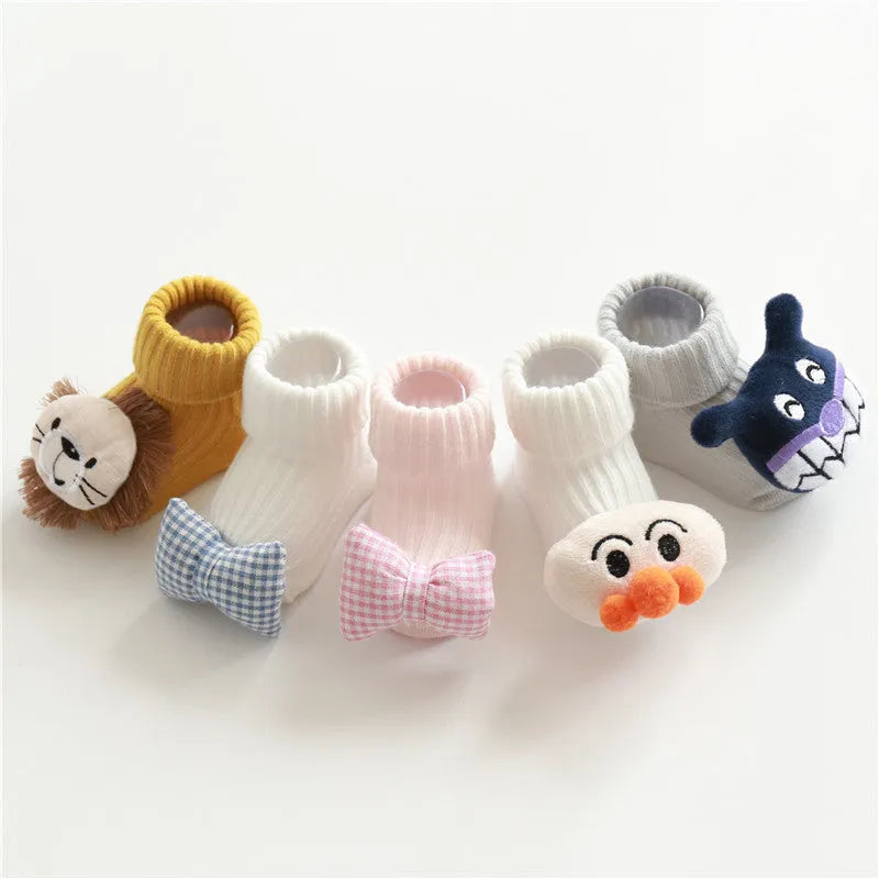 Cotton baby floor socks in various colours and patterns including pink bows, grey stars, and panda design.