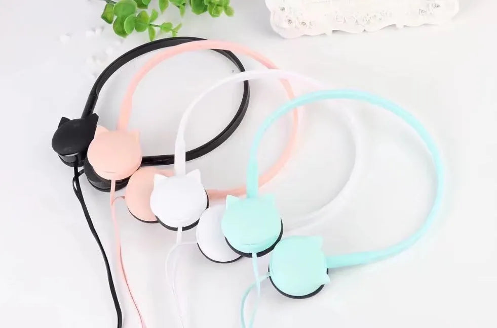 Kitten ear headphones in black with head-mounted design and 3.5mm plug on a desk next to a laptop.