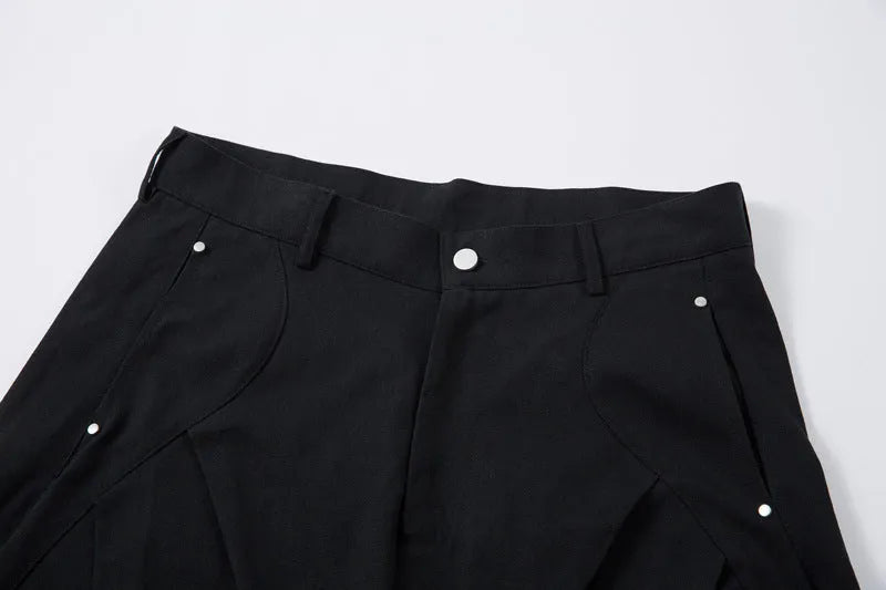 Men's black pleated wide-leg cotton trousers showing loose-fitting casual design