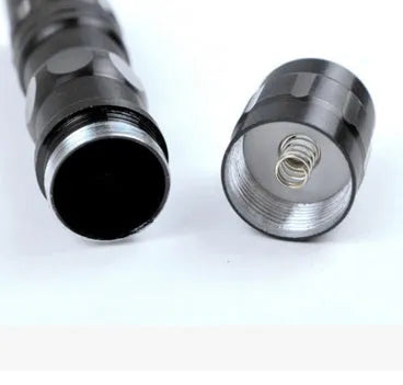 Black aluminium mini LED flashlight on a dark background.