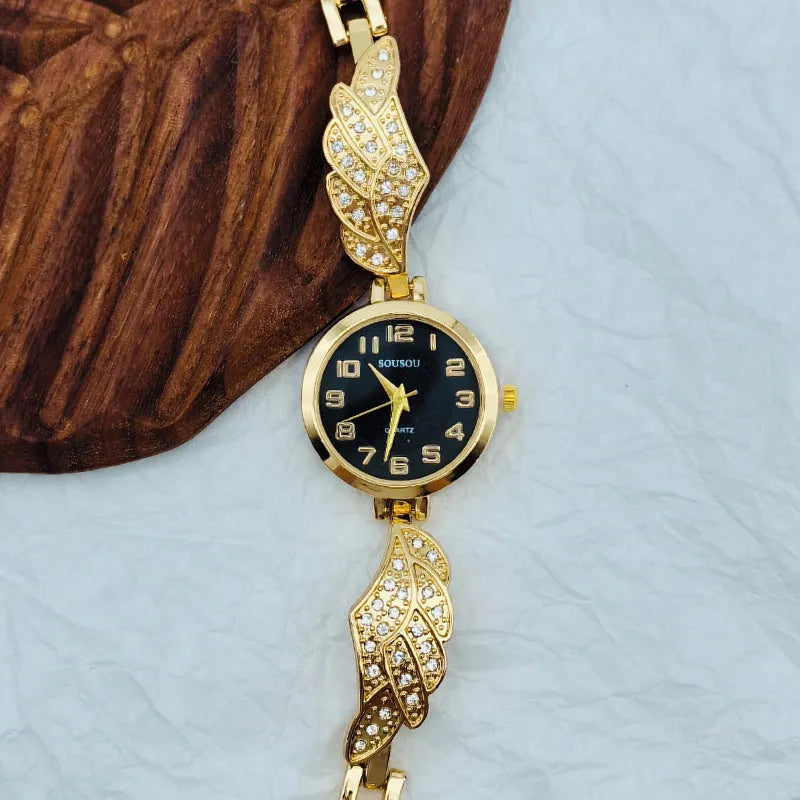 A stainless steel women's watch with a round dial on a metal strap, showing a gold-coloured face.