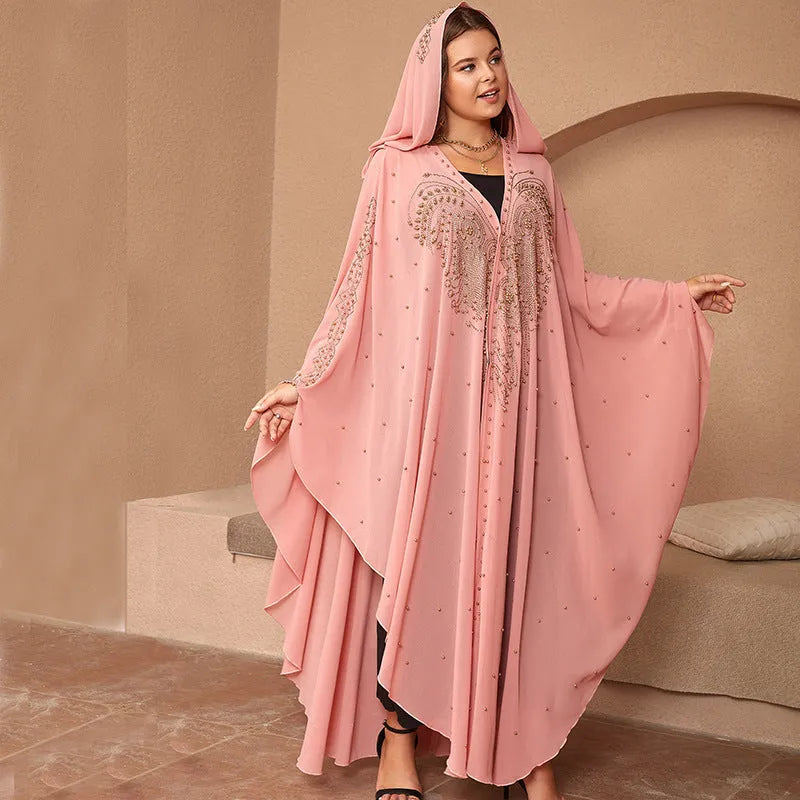 A woman wearing a long purple chiffon cape with rhinestone beading draped over the shoulders.