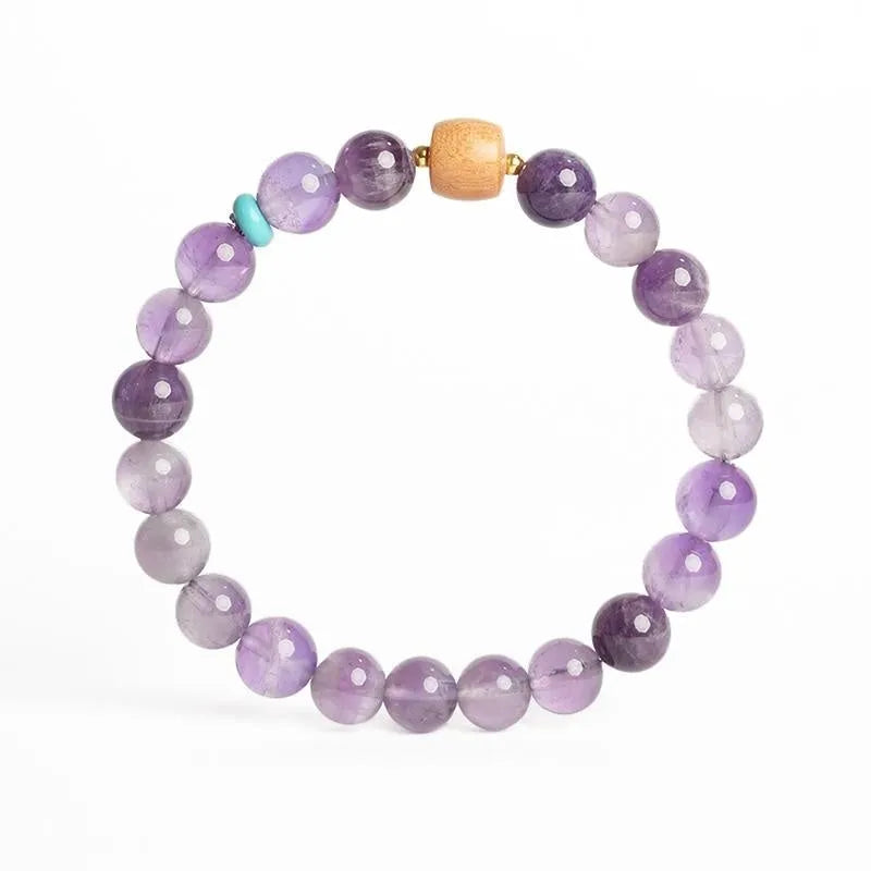 Handmade purple amethyst crystal bracelet for women on a wrist.