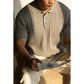 Men's khaki short sleeve business top on a hanger, showing the collar and button placket.