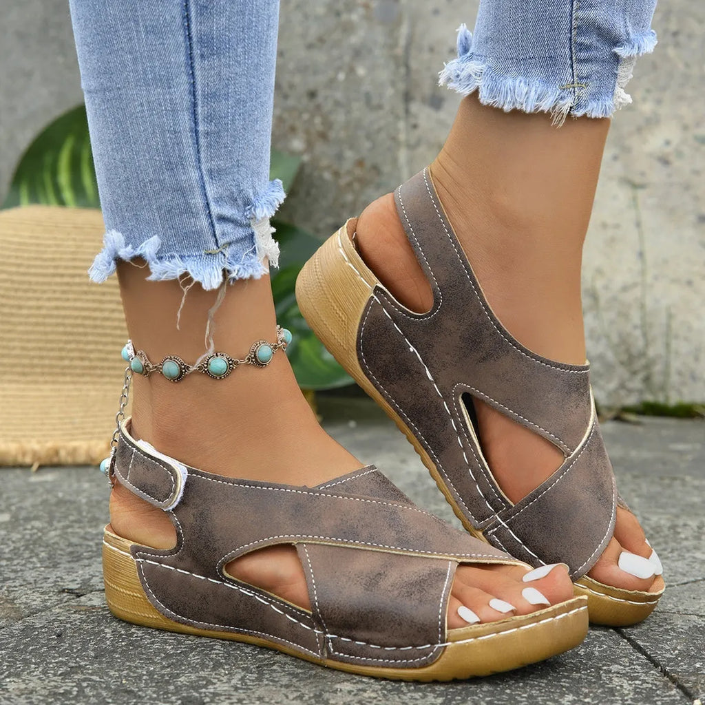 Women's brown roman platform sandals with a skirt detail and Velcro strap closure on a white background.