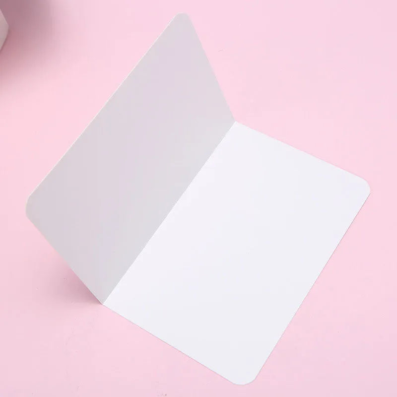 Pack of 100 blank folded kraft cards in 10x15cm size on a craft table