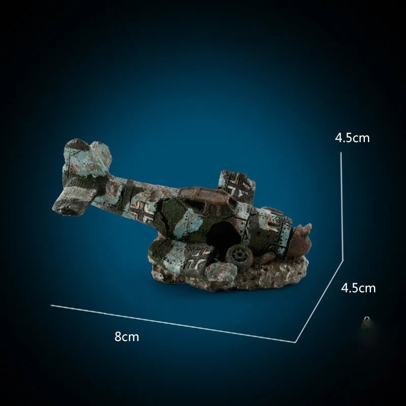 Resin simulated aircraft wreckage aquarium ornament 8cm by 4.5cm by 4.5cm on dark substrate