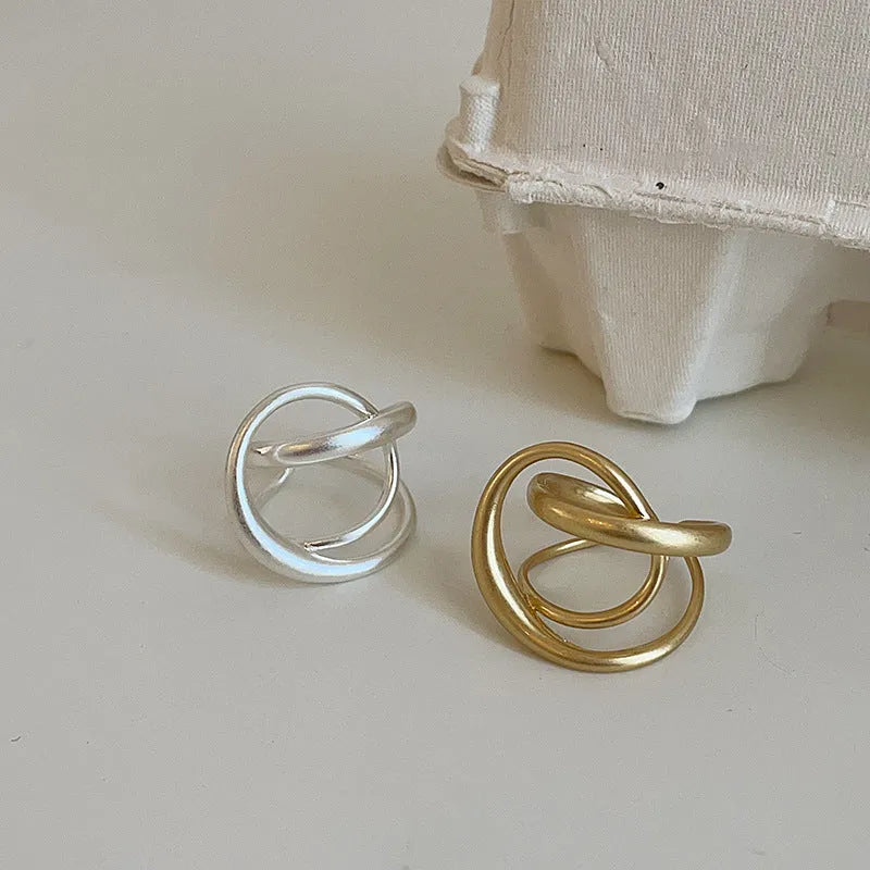 Geometric open ring with interlaced matte metal construction in gold and silver plating options