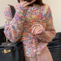 Retro-style pink and green knitted rainbow cardigan sweater on a hanger.