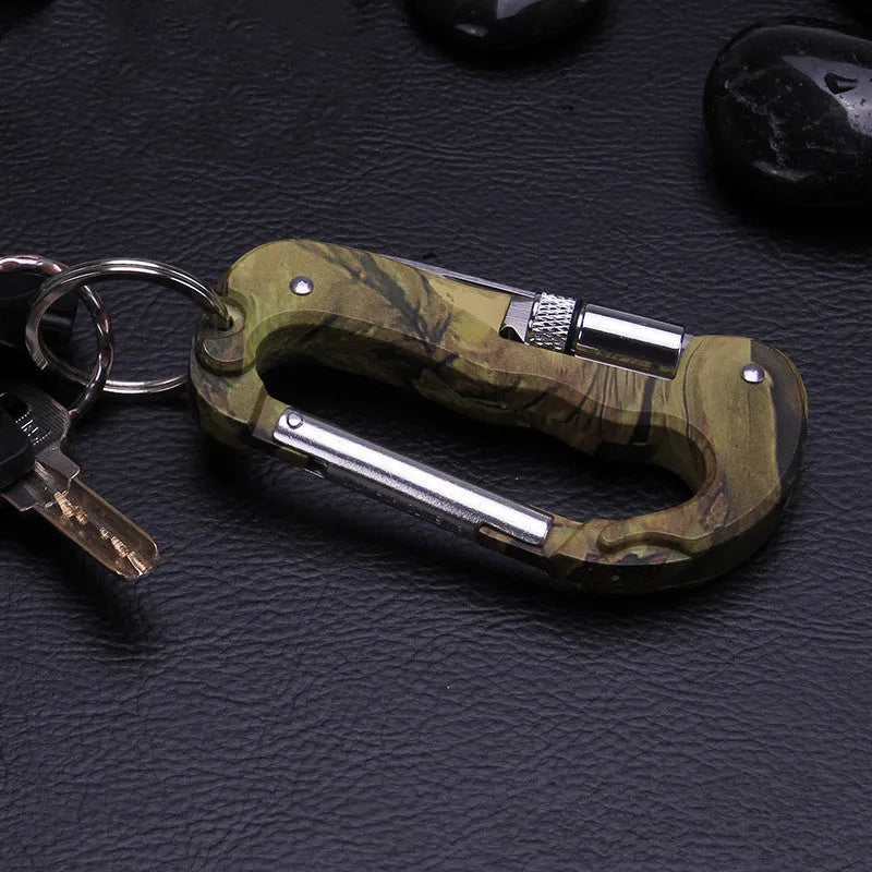 Camouflage multifunctional carabiner with knife, saw, and LED light on a black background