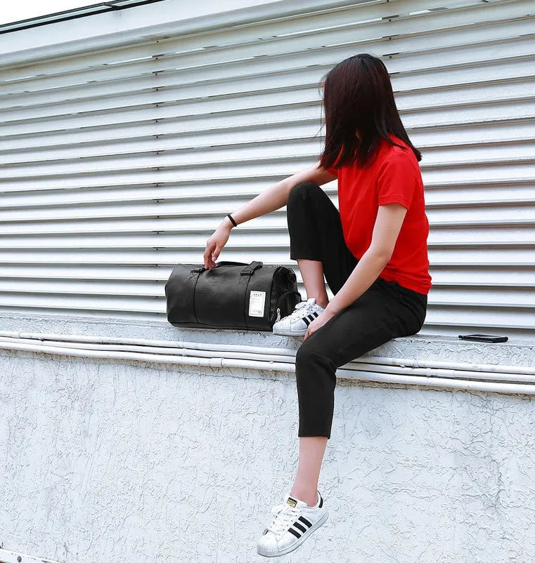 Black waterproof sports fitness bag with a separate shoe compartment and a diagonal carry strap.