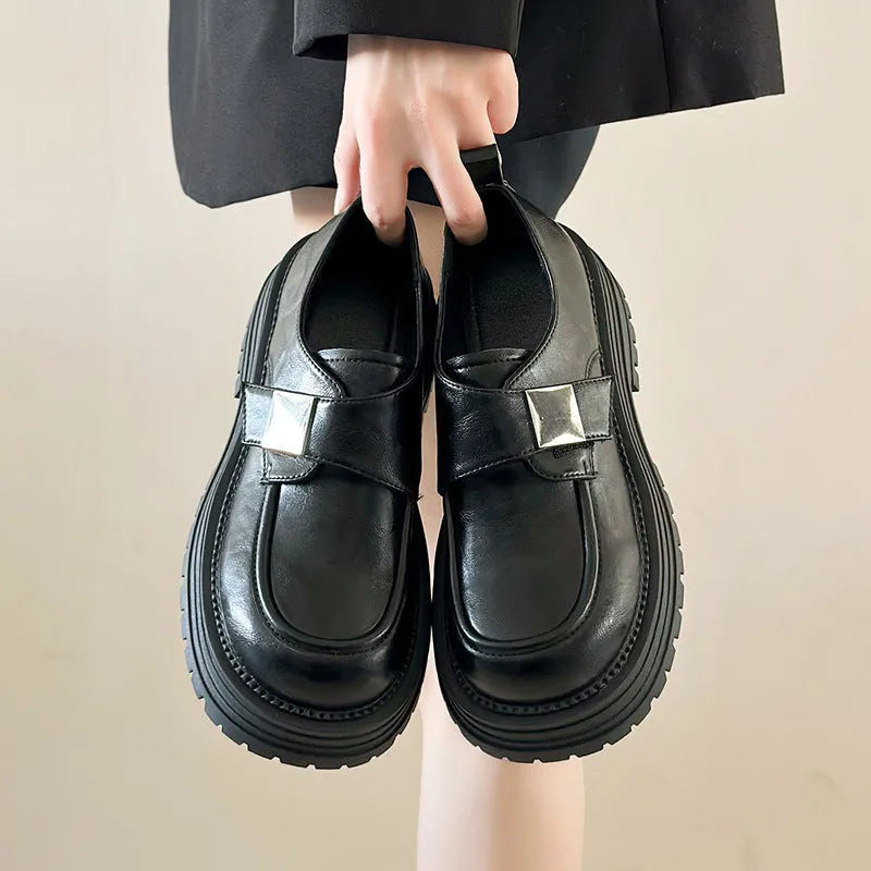 Retro platform loafers for women in solid colour black with square heel and round toe on a neutral background