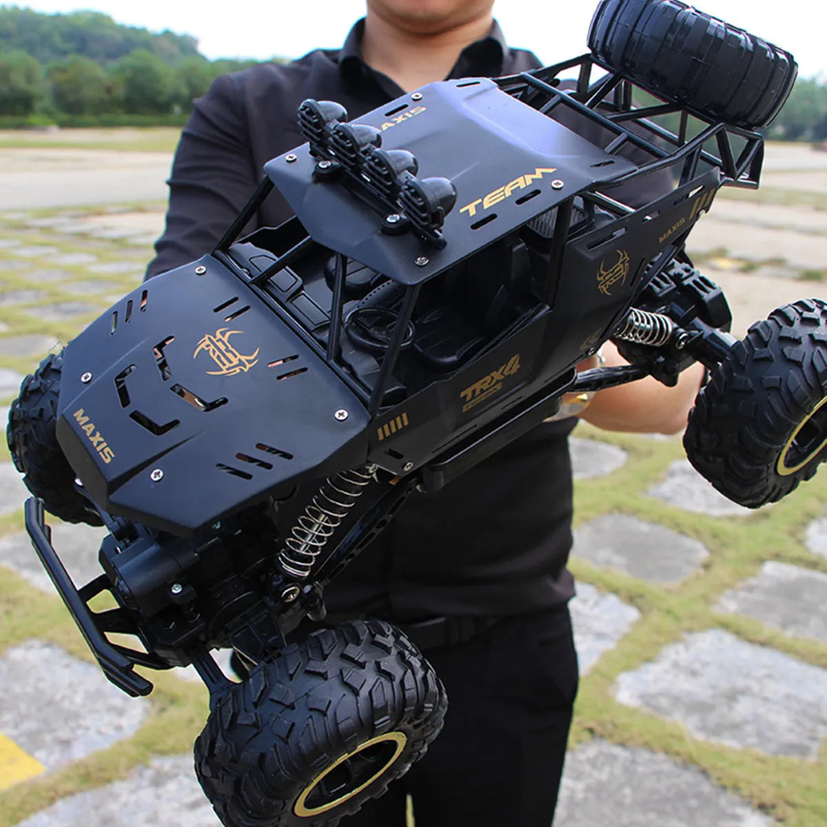 Large black 4WD remote control off-road climbing car on rough ground