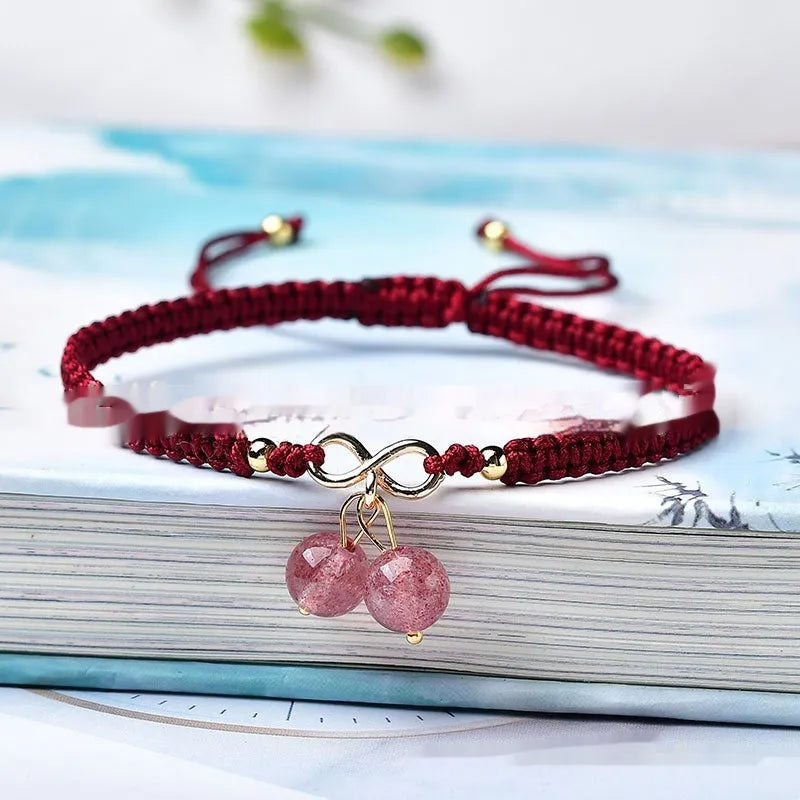 Women's natural strawberry quartz bracelet with a detailed cherry-shaped crystal charm.