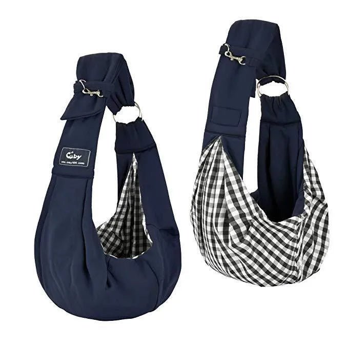 Light grey polyester pet sling carrier with cell phone pocket, worn around waist, holding a small dog