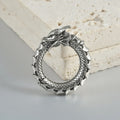 Pair of large antique silver dragon-shaped geometric ear cuffs with hollow-out detail on a plain background.