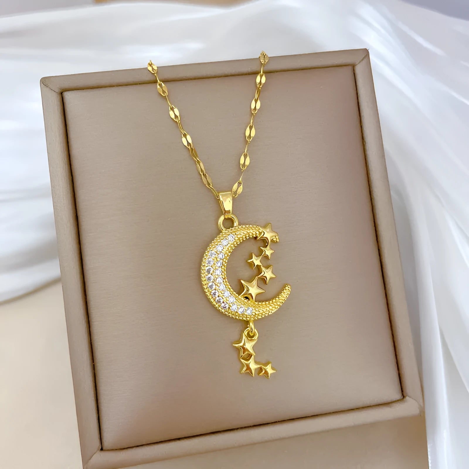 A218 geometric moon pendant necklace with diamond-cut facets and a dangling tassel on a silver chain.