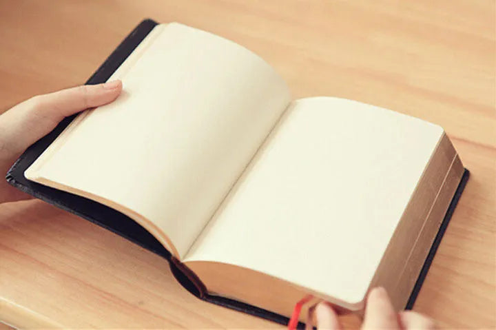 Large thick leather Phnom Penh notebook in gold, A6 size, 480 pages, open on a desk