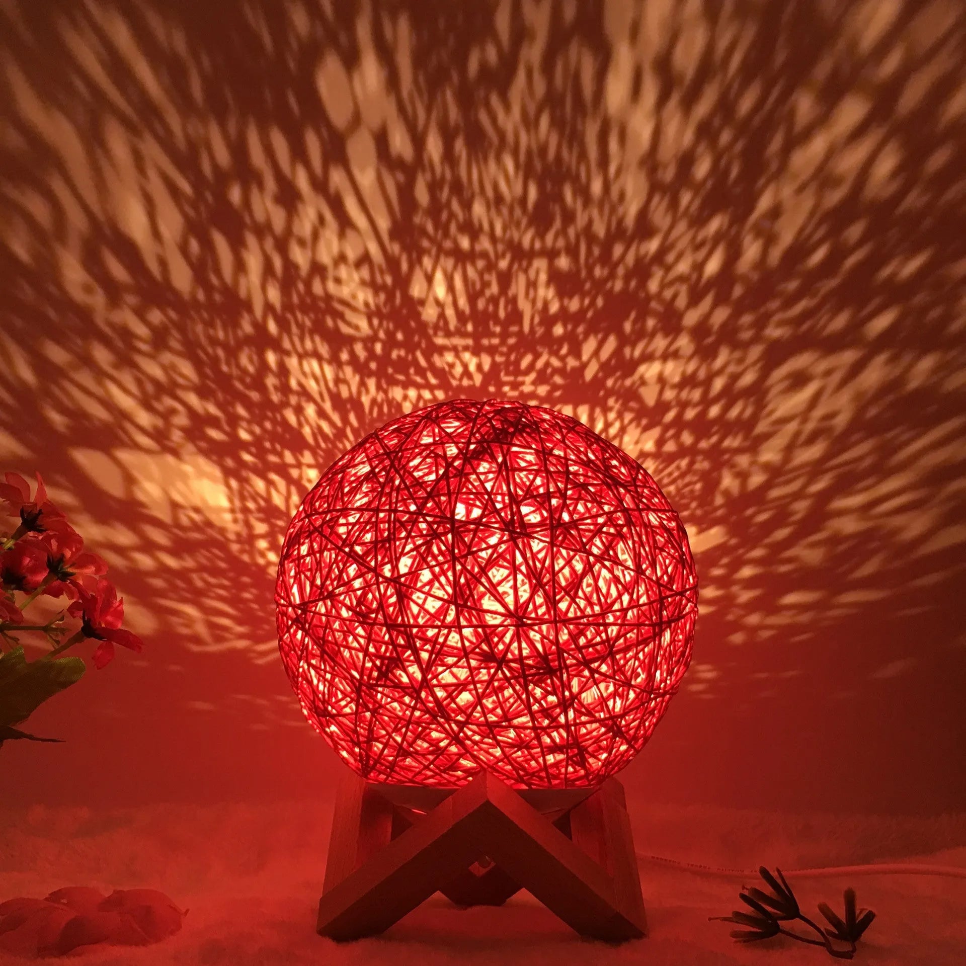Rattan ball table lamp with woven shade and warm LED lighting on wooden surface