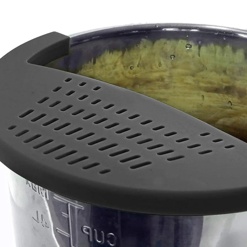 Black silicone food oil drainer clipped onto a pressure cooker liner for draining liquid