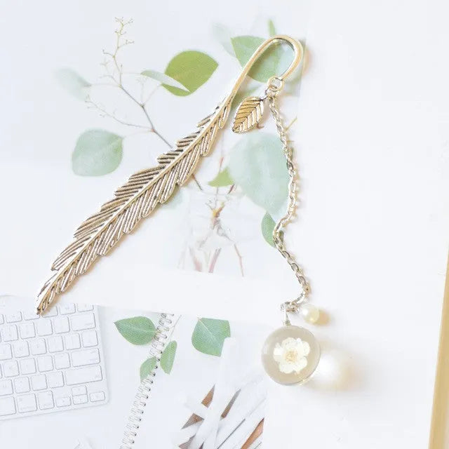 Creative metal bookmark with a dried flower inside, showing colour options like blue starry sky and dandelion.